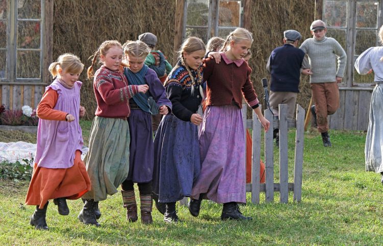 Young girls dressed in local costumes holding around each other during the local play, “Klemetspelet” in Korgen.